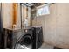 Basement laundry room featuring a dark gray washer and dryer set and a small window for natural light at 6730 W 84Th Cir # 96, Arvada, CO 80003