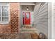 Close-up of the front porch, showcasing a red door, brickwork, and decorative elements at 7975 S Gaylord Way, Centennial, CO 80122