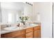 Bathroom featuring double sink vanity with granite countertop and wood cabinetry at 21572 E Union Dr, Aurora, CO 80015