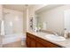 Bright bathroom with a granite countertop, dark wood cabinets, and a shower and tub combination at 21572 E Union Dr, Aurora, CO 80015