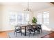 Sun-filled dining room with large windows, hardwood floors, and a modern chandelier at 21572 E Union Dr, Aurora, CO 80015