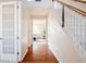 Hallway with hardwood floors, a staircase, and a view into the sun-filled living room at 21572 E Union Dr, Aurora, CO 80015