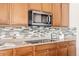 Close up on the modern kitchen with granite countertops, wooden cabinetry, and stainless steel appliances at 21572 E Union Dr, Aurora, CO 80015