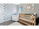 Bedroom features a wood crib, a comfy white glider chair, and bright natural light at 2714 S Raleigh St, Denver, CO 80236