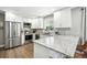 Bright kitchen featuring stainless steel appliances, white cabinets and granite counters at 2714 S Raleigh St, Denver, CO 80236
