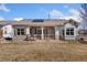 Exterior shot of backyard features stucco, stone accents, solar panels, covered porch, and low-maintenance landscaping at 4932 Democrat Dr, Broomfield, CO 80023