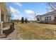 Backyard lawn area with a walking path, exterior view of the house, and partial patio on the left at 4932 Democrat Dr, Broomfield, CO 80023