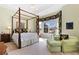 Comfortable bedroom with a four-poster bed, seating area, and bright window at 4932 Democrat Dr, Broomfield, CO 80023