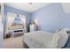 A serene bedroom features light blue walls, a bed, and a window with a bench at 4932 Democrat Dr, Broomfield, CO 80023