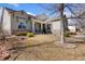 Landscaped front yard featuring a stone-accented home with covered front porch and mature tree at 4932 Democrat Dr, Broomfield, CO 80023
