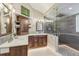 Bathroom featuring wood cabinets, dual sinks, quartz countertop, and a walk-in shower at 1832 W 33Rd Ave, Denver, CO 80211