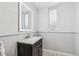 Bathroom with a dark vanity, a lighted mirror, and modern wall tiling at 1832 W 33Rd Ave, Denver, CO 80211
