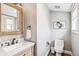 Clean, modern half bathroom featuring a wooden framed mirror and updated fixtures at 1832 W 33Rd Ave, Denver, CO 80211