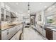 Bright kitchen boasts a long island, marble countertops, stainless steel appliances, and custom cabinetry at 1832 W 33Rd Ave, Denver, CO 80211