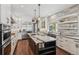Bright kitchen featuring white cabinetry, stainless steel appliances, and dark wood island with marble top at 1832 W 33Rd Ave, Denver, CO 80211