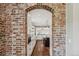 View of a kitchen through a brick archway; kitchen features stainless appliances and ample cabinet space at 1832 W 33Rd Ave, Denver, CO 80211