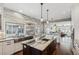 Spacious kitchen with a large island, stainless steel sink, and view into the living area at 1832 W 33Rd Ave, Denver, CO 80211