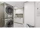 Laundry room with stacked washer and dryer, white cabinets, and countertop at 1832 W 33Rd Ave, Denver, CO 80211