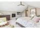 Bright main bedroom featuring a fireplace, ceiling fan, sitting area, and large mirror at 1832 W 33Rd Ave, Denver, CO 80211