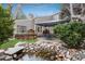Serene backyard with a pond, gazebo, deck, and mature landscaping at 1585 W Briarwood Ave, Littleton, CO 80120
