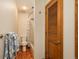 Cozy bathroom with wood-look flooring, a tiled shower, and wood cabinet with an open door on the right at 1585 W Briarwood Ave, Littleton, CO 80120