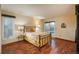 Bright bedroom featuring a sliding glass door to the back, wood-look floors, and a large window at 1585 W Briarwood Ave, Littleton, CO 80120