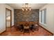 Traditional dining room boasts stone accent wall, wood floors, and a decorative light fixture at 1585 W Briarwood Ave, Littleton, CO 80120