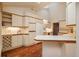 Bright kitchen with white cabinets, skylight, tiled countertops and backsplash, and wood-look floors at 1585 W Briarwood Ave, Littleton, CO 80120