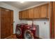 Cozy laundry room features red washer/dryer set, wood cabinets, and matching wood door at 1585 W Briarwood Ave, Littleton, CO 80120