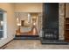 Open concept living room features stone fireplace, tiled flooring, and a view into the kitchen at 1585 W Briarwood Ave, Littleton, CO 80120