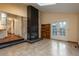 Spacious living room featuring a floor-to-ceiling stone fireplace, hardwood floors and access to the backyard at 1585 W Briarwood Ave, Littleton, CO 80120