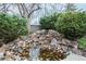 Lush rock water feature with a small pond and vibrant greenery for a tranquil backyard setting at 1585 W Briarwood Ave, Littleton, CO 80120