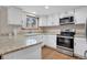Updated kitchen featuring stainless steel appliances, granite countertops, and white cabinets at 5603 S Pagosa Ct, Centennial, CO 80015