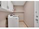 Bright laundry room featuring a washer and dryer and white cabinets and shelf at 5603 S Pagosa Ct, Centennial, CO 80015