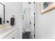 Elegant bathroom featuring a shower with glass door and white tiles, next to a white door at 1232 N Yates St # 3, Denver, CO 80204