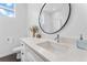 Modern bathroom with quartz counters, black hardware, and a round mirror at 1232 N Yates St # 3, Denver, CO 80204