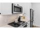 Updated kitchen with stainless steel microwave and a modern black cooktop at 1232 N Yates St # 3, Denver, CO 80204
