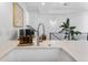 Close-up of a kitchen sink with a modern faucet, soap dispensers, and a view of the staircase at 1232 N Yates St # 3, Denver, CO 80204