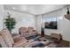 Comfortable living room featuring cozy seating, a large TV, and bright natural light at 128 Chapel Hill Cir, Brighton, CO 80601