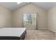 Vaulted ceiling bedroom featuring neutral carpet, one window with blinds, and a bed frame with an aspen mattress at 18171 E Arizona Ave # B, Aurora, CO 80017