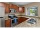 This kitchen features wood cabinetry, granite countertops, and stainless steel appliances at 18171 E Arizona Ave # B, Aurora, CO 80017