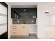 Basement wet bar with dark cabinetry, glass-front doors and linear tile backsplash at 3120 Braun Ct, Golden, CO 80401