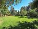 Sunny backyard with a large grassy area at 1866 W Davies Ave, Littleton, CO 80120