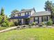 Two-story house with a brick and beige facade, attached garage, and well-maintained lawn at 1866 W Davies Ave, Littleton, CO 80120