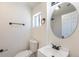 Bathroom with a round mirror and a black faucet on the sink at 3570 Center Ave, Denver, CO 80219