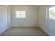 The carpeted bedroom has bright natural light from two windows at 3570 Center Ave, Denver, CO 80219