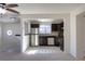 Bright kitchen with stainless steel appliances and brown cabinets next to living space at 3570 Center Ave, Denver, CO 80219