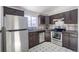 Kitchen with stainless steel appliances, dark brown cabinets, and light tile flooring at 3570 Center Ave, Denver, CO 80219