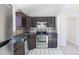 Close-up of the kitchen with stainless steel appliances and dark wood cabinets at 3570 Center Ave, Denver, CO 80219