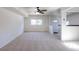 Open living room with neutral carpet and a bright kitchen to the side at 3570 Center Ave, Denver, CO 80219